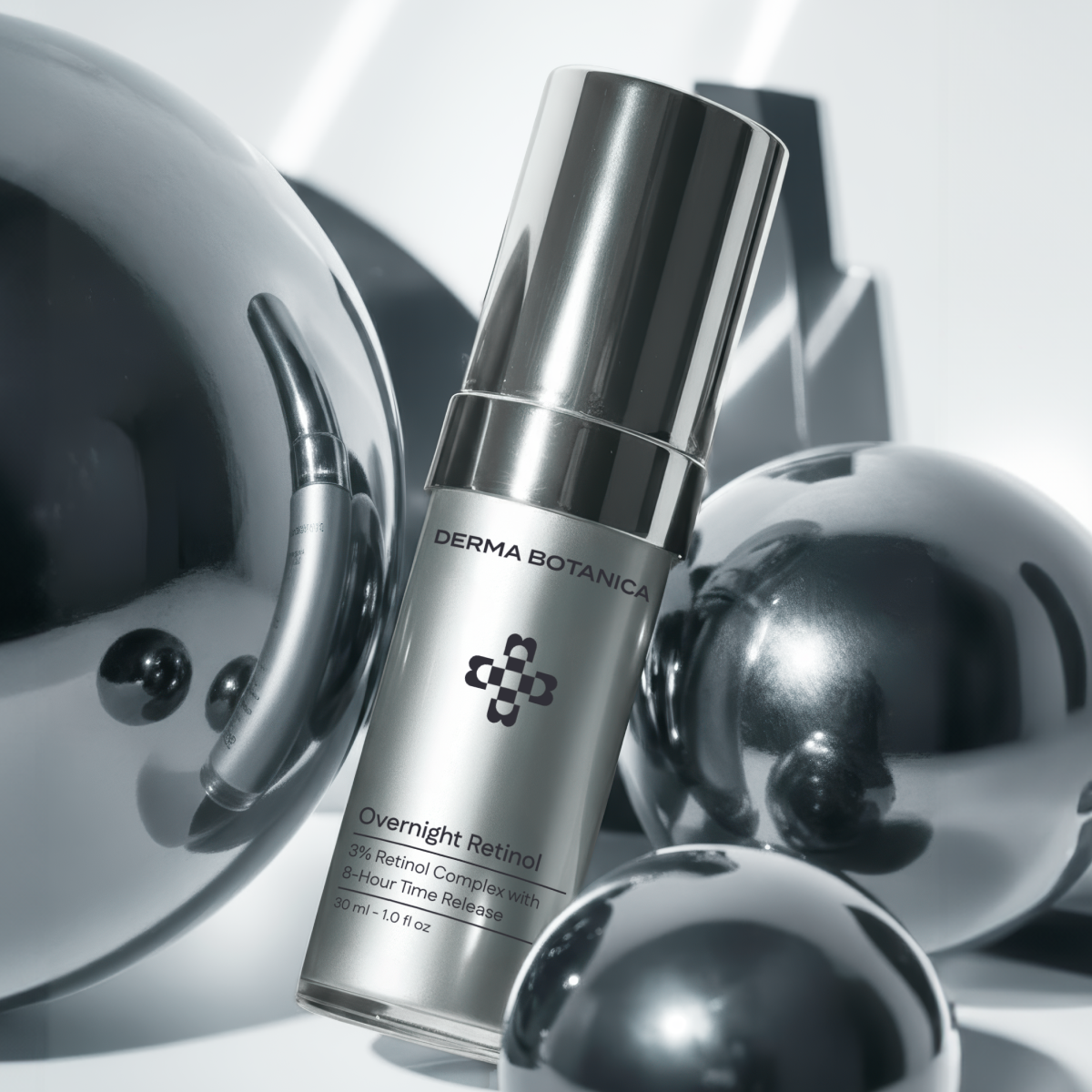 Derma Botanica Overnight Retinol Serum bottle with metallic spheres on a reflective surface